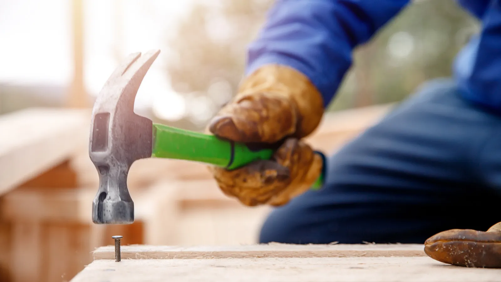 IPM maintenance team member hammering a nail