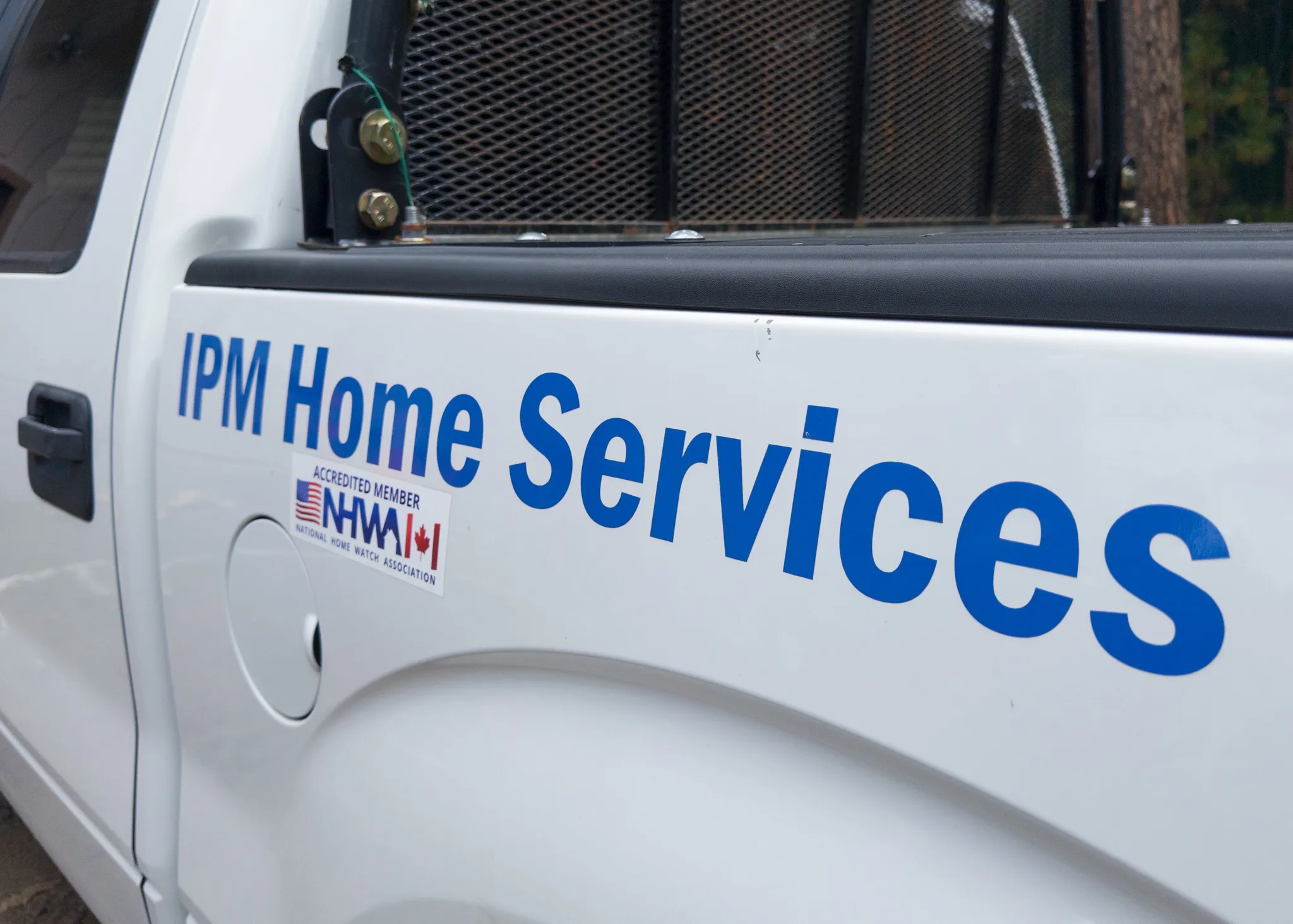 IPM Home Services truck door showing National Home Watch Association accredited member decal